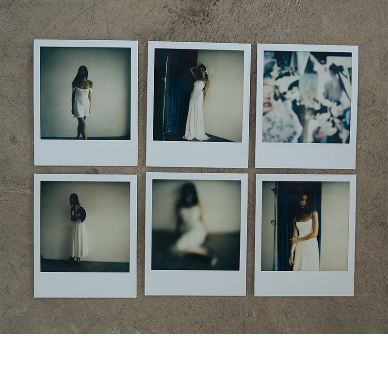 Six Polaroid photos arranged in two rows on a concrete surface, each showing a woman in a white dress; four are blurred and two show her posing.