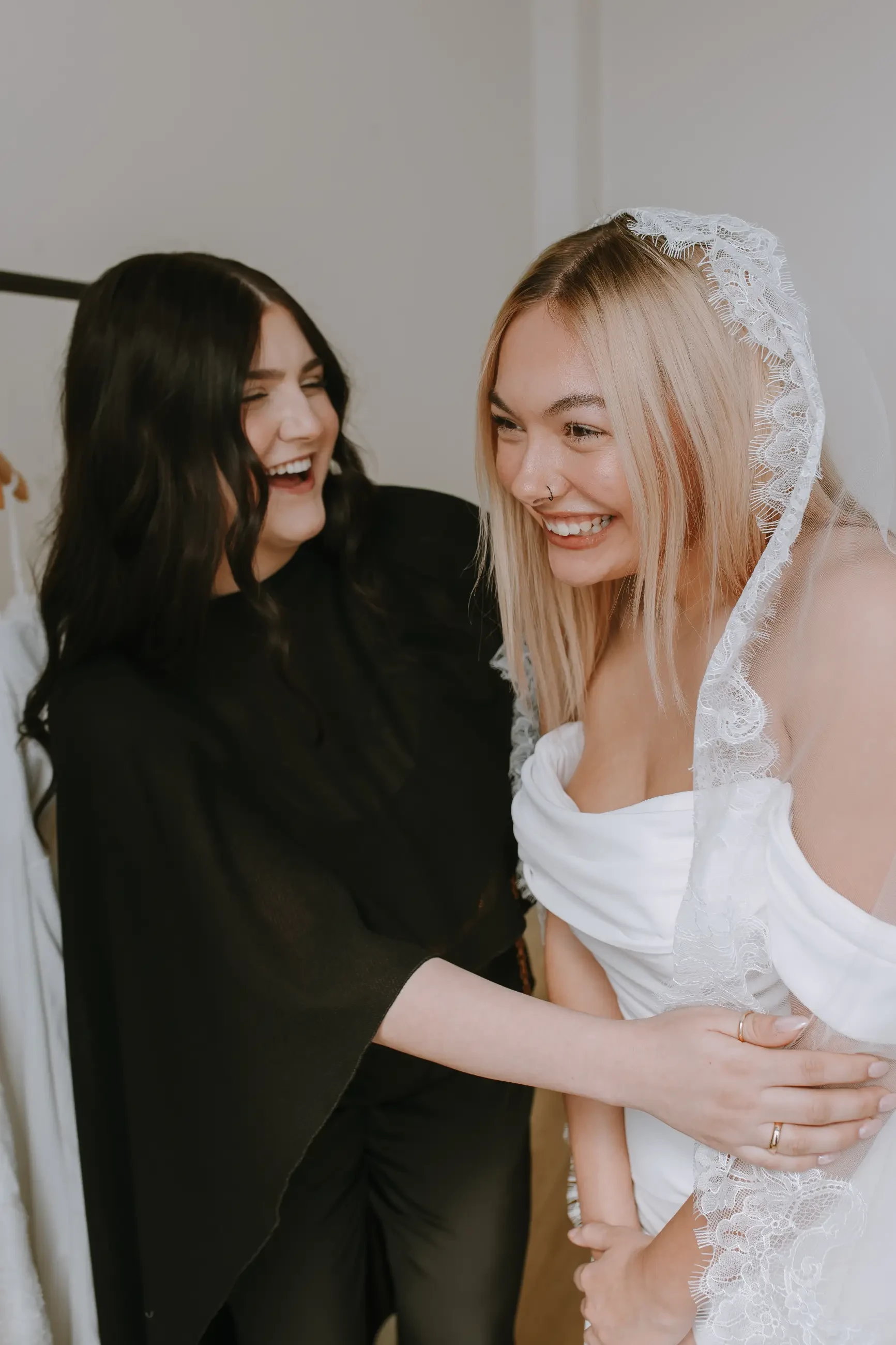 image shows a stylist smiling with a bride