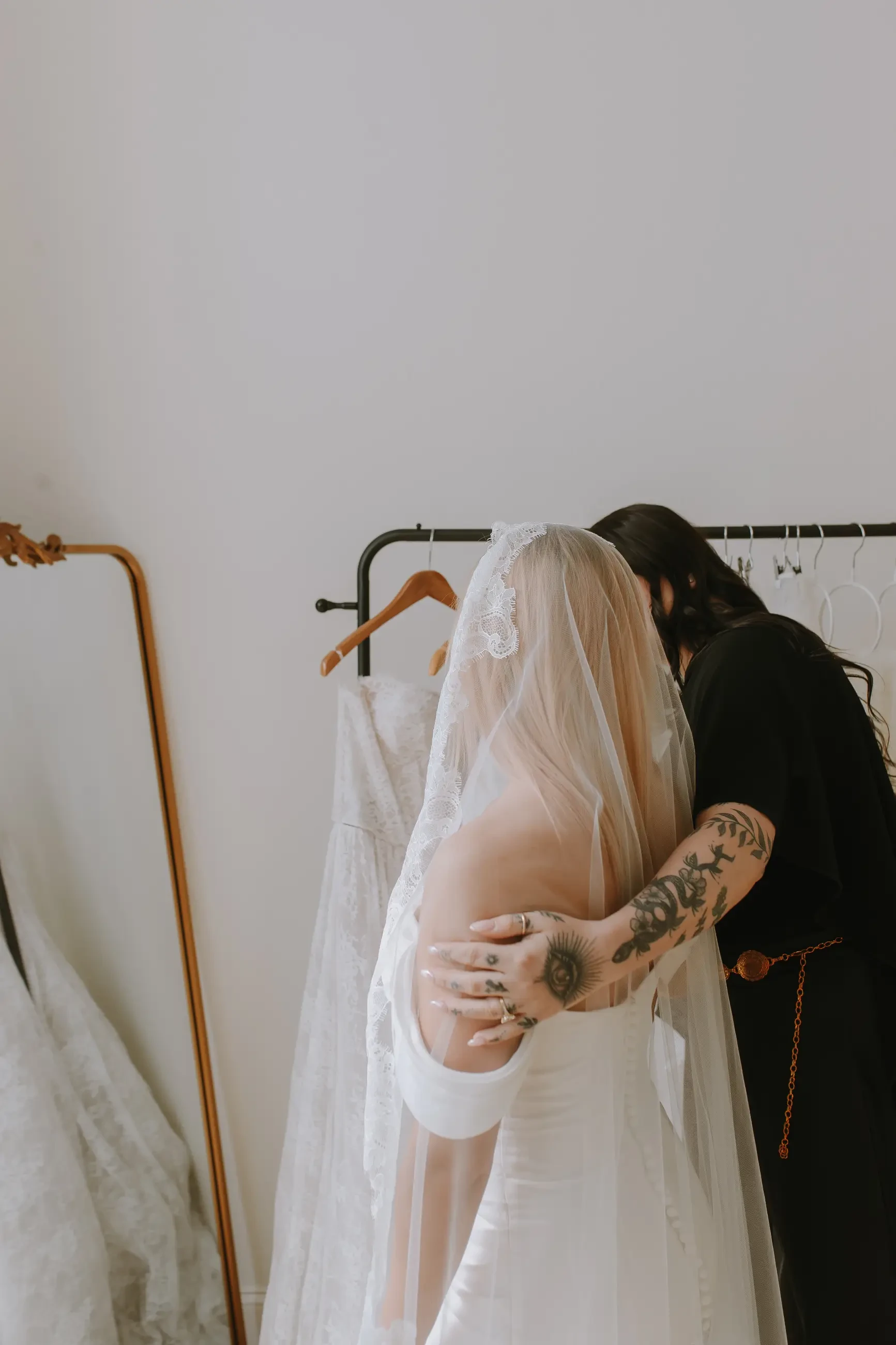 image shows a stylist hugging a bride