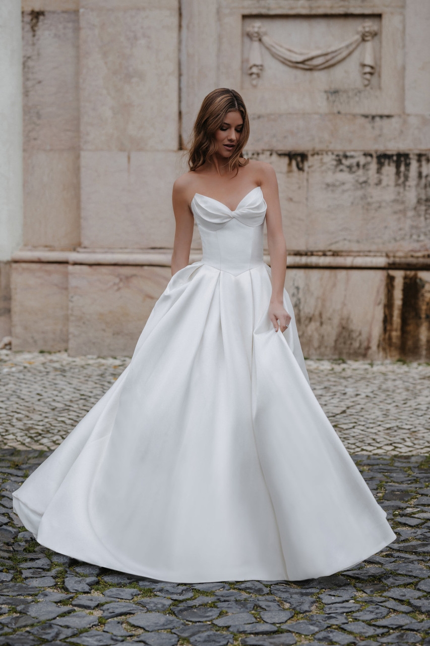 Model wearing a white gown by Abella